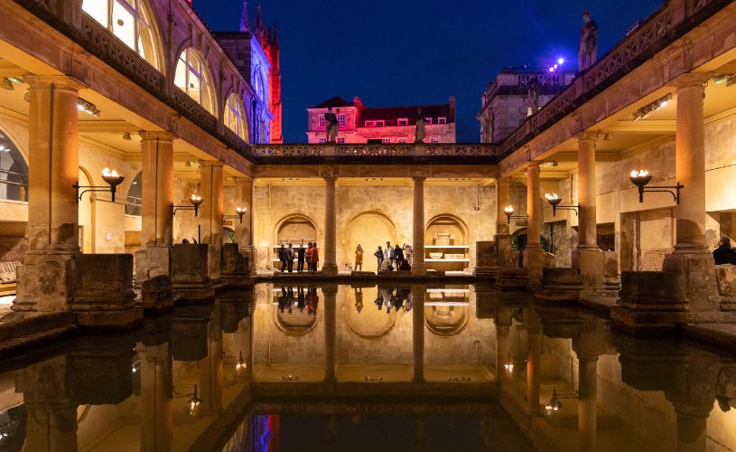 The Great Bath at Roman Baths lit by torchlight